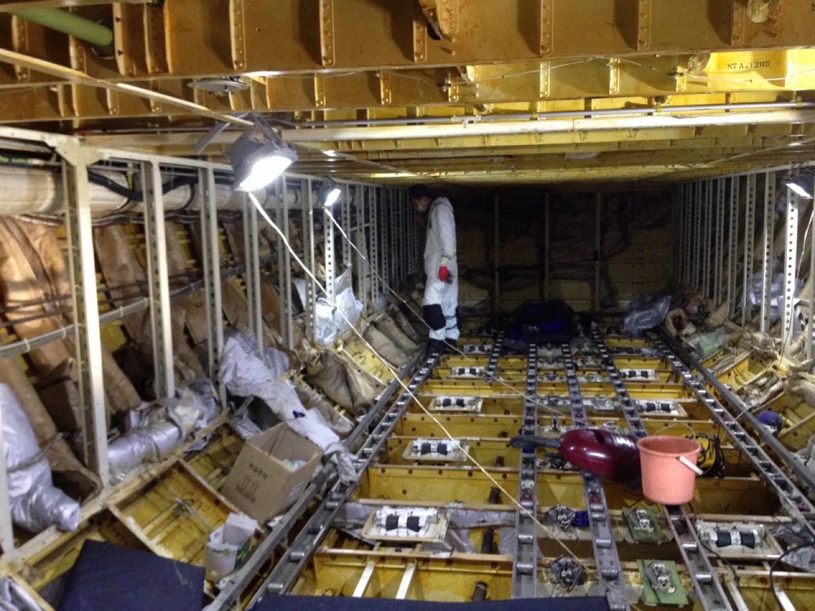 Technician working inside a stripped aircraft cabin