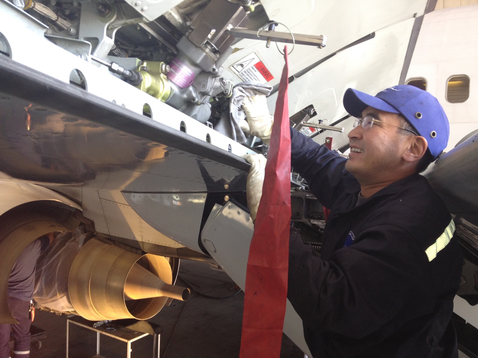 Technician working beside an aircraft engine